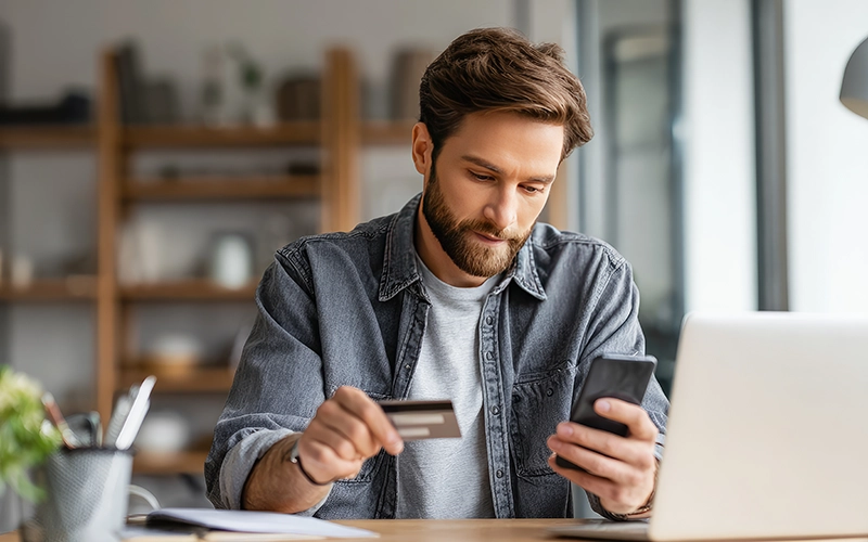 man on phone holding credit card